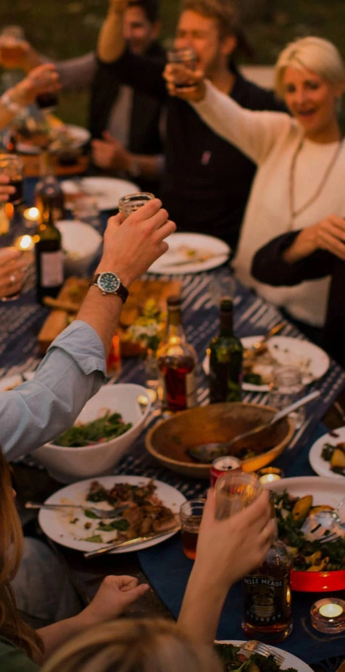 Friends toasting around a long dinner table