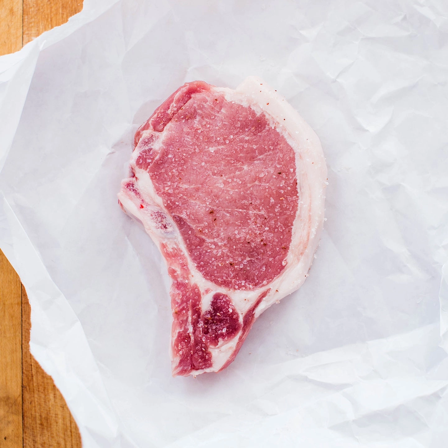 Raw pork chop on white paper